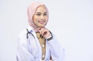 Ärztin mit Hijab über weißem Hintergrund Studio. foto