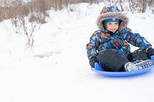 Rutsche, die die Winteraktivität für Kinder hinunterfährt foto