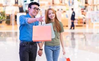 asiatisches paar, das im einkaufszentrum einkauft foto