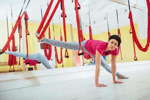 junge Frauen, die im Studio Yoga-Übungen oder Luft-Yoga-Antigravitation machen. foto