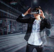 junges mädchen, das erfahrung mit vr-headset bekommt, verwendet augmented-reality-brillen und befindet sich in einer virtuellen realität. Nachts in der Stadt foto