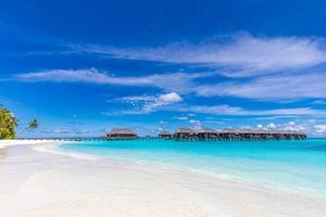 Überwasservillen in der blauen tropischen Lagune. endloser meerblick mit horizont und luxuriösen wasservillen oder bungalows, malediven oder französisch-polynesien foto