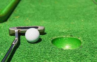 Golfball und Golfschläger auf Kunstrasen foto