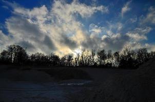 Steinbruch mit Bäumen bei Sonnenuntergang foto