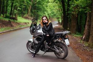 Ein attraktives sexy Mädchen auf einem Sportmotorrad, das draußen posiert foto