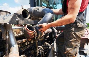 kombinieren maschinenservice, mechaniker reparieren motor im freien foto