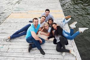 gruppe schöner junger leute auf dem pier, freundzufriedenheit schafft emotionales leben foto