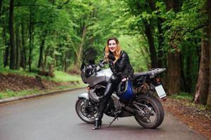 Ein attraktives sexy Mädchen auf einem Sportmotorrad, das draußen posiert foto