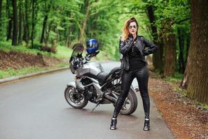 Ein attraktives sexy Mädchen auf einem Sportmotorrad, das draußen posiert foto