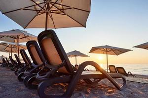 Malerischer Blick auf den Sandstrand am Strand mit Sonnenliegen und Sonnenschirmen, die sich gegen das Meer und die Berge öffnen. Hotel. Erholungsort. tekirowa-kemer foto