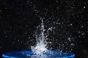 Spritzwasser, isoliert auf schwarzem Hintergrund foto
