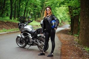 Ein attraktives sexy Mädchen auf einem Sportmotorrad, das draußen posiert foto