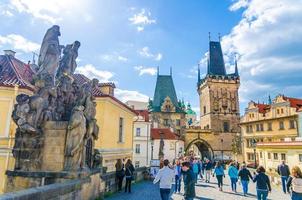 Menschen gehen die kopfsteingepflasterte Fußgänger-Karlsbrücke hinunter foto