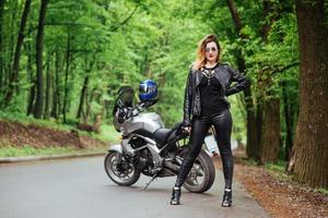 Ein attraktives sexy Mädchen auf einem Sportmotorrad, das draußen posiert foto
