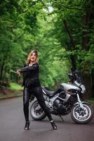 Ein attraktives sexy Mädchen auf einem Sportmotorrad, das draußen posiert foto