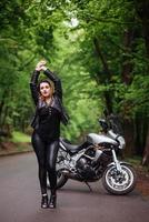 Ein attraktives sexy Mädchen auf einem Sportmotorrad, das draußen posiert foto