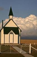 Gewitterwolken bilden sich hinter einer Landkirche foto