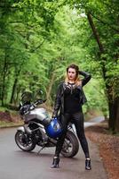 Ein attraktives sexy Mädchen auf einem Sportmotorrad, das draußen posiert foto