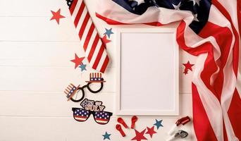 leerer weißer Fotorahmen für Mockup-Design auf hölzernem Hintergrund der amerikanischen Nationalflagge mit Dekorationen foto