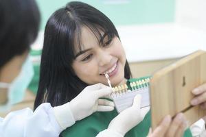 ein zahnarzt untersucht die zähne einer patientin mit der aufhellungsstufe foto
