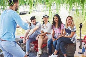 gruppe von freunden, die sich entspannen und zusammen spielen. junge Leute plaudern auf der Straße, wiegen und spielen zusammen foto