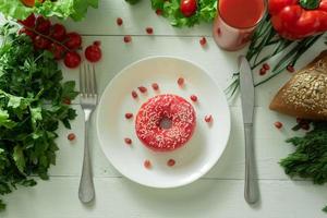 ein leckerer donut liegt auf einem teller und isst, um ihn zu essen. Probleme der richtigen Ernährung und das Konzept der Wahl zwischen gesunder und nicht gesunder Ernährung foto