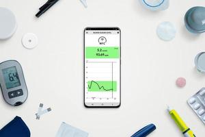 Telefon mit Blutzucker-App, umgeben von Zubehör, um Diabetes unter Kontrolle zu halten. Draufsicht, flache Laienzusammensetzung foto