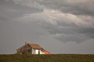 Gewitterwolken über einem alten Bauernhaus in Saskatchewan foto