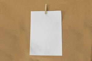 Weißbuch und Holzclip auf braunem Papierhintergrund. foto