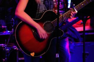 Frau mit Gitarre und Band foto