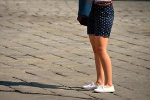 Frau und Shorts mit weißen Turnschuhen foto