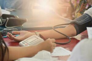 nahaufnahme des patientenarms während der blutdruckmessung bei der ärztlichen beratung. mobile medizinische Einheit foto