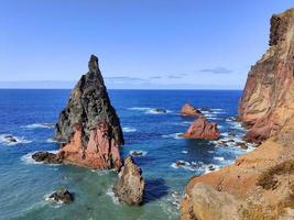 Herrlicher Blick über das Meer und wunderschöne braune und rote Felsen. Wellen, die an den Klippen krachen. Insel mitten im Ozean. Portugal. um die Welt reisen. lebendige blaue Farben. foto