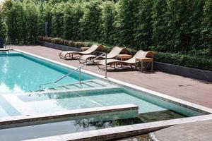 Schwimmbadleiter und Sonnenliege am Pool, luxuriöser Außenpool und moderne Dekoration des Resorthotels. Entspannungsschwimmbad im Sommerurlaub und Freizeiturlaub. foto