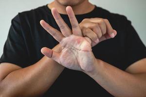 Office-Syndrom-Konzept. kleiner Finger wird nach der Arbeit massiert und gedehnt. Nahaufnahme isoliert auf blauem Hintergrund. Vorhandansicht. foto