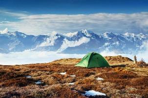 Zelt vor der Kulisse schneebedeckter Berggipfel. der blick von den bergen auf den berg ushba mheyer, georgia. Europa foto