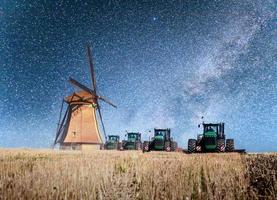 bunte frühlingsnacht mit traditionellem holländischen windmühlenkanal in rotterdam. Holzsteg in der Nähe des Seeufers. Holland. Niederlande. fantastischer Sternenhimmel und die Milchstraße. foto