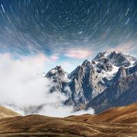 fantastischer Sternenhimmel. schneebedeckte Gipfel. Kaukasischer Hauptkamm. Blick auf die Berge vom Mount Ushba Meyer, Georgia. Europa foto