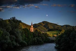 Kirchturm auf der Seite des Flusses foto