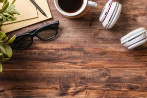 draufsicht arbeitstisch mit kopfhörer und notizbuch, kaffeetasse auf holztischhintergrund foto