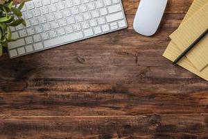 Draufsicht Holztisch mit Tastatur und Notebook-Arbeitstisch mit Kopierraum foto