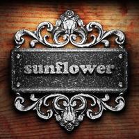 Sonnenblumenwort aus Eisen auf Holzhintergrund foto