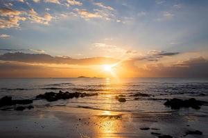 Sonnenuntergang Landschaft auf den Strandfelsen im Vordergrund foto