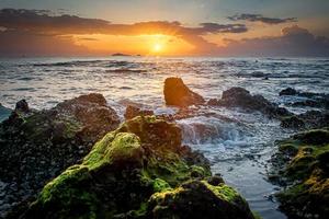 Sonnenuntergang Landschaft auf den Strandfelsen im Vordergrund foto