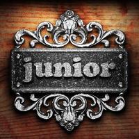 Junior-Wort aus Eisen auf Holzhintergrund foto