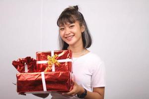 asiatische junge Frau lächelnd bringen einige Geschenkboxen weißen Hintergrund. foto