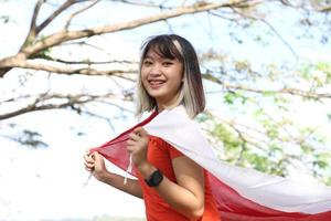 Aufgeregte Asiatin mit indonesischer Flagge am Unabhängigkeitstag Indonesiens foto