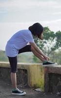 junge asiatin hat ihre schuhe vorbereitet, bevor sie morgens läuft und joggt foto