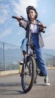 junge asiatische frau bricht fahrrad, bevor sie zur arbeit geht foto