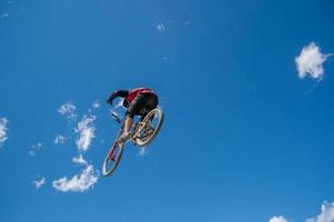 Liivigno Italien 2014 Junge, der die Abfahrt mit dem Fahrrad mit einem Sprung beendet foto